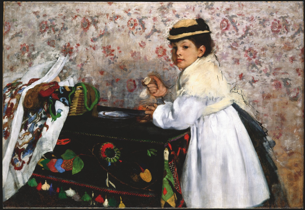 Painting of a young girl wearing a white dress and hat holding a small object in her hand and leaning against a black table