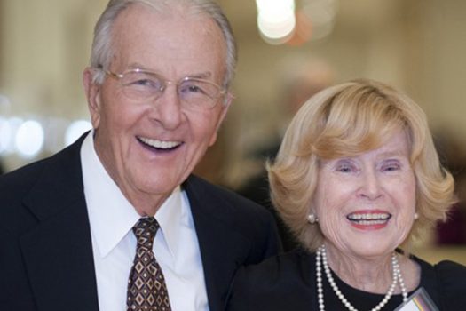 Two people looking at the camera and smiling.