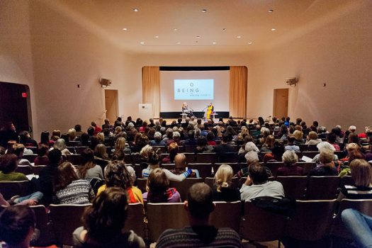 guests seated in an auditorium listening to a lecture