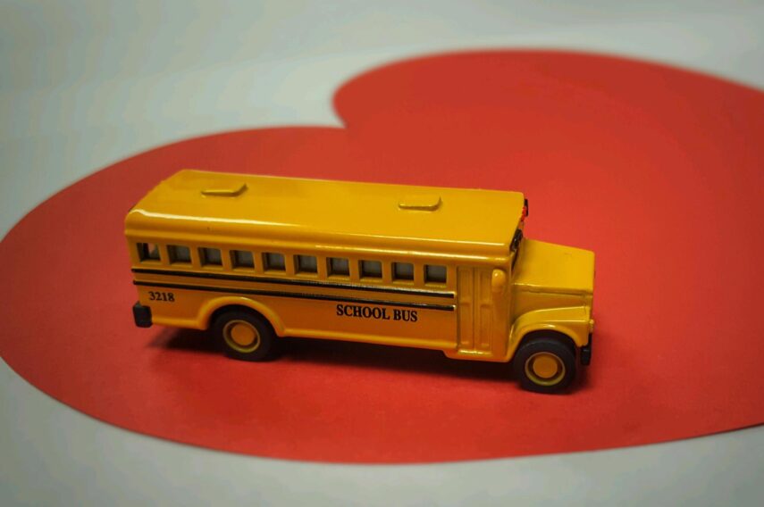 Toy yellow school bus on top of a heart