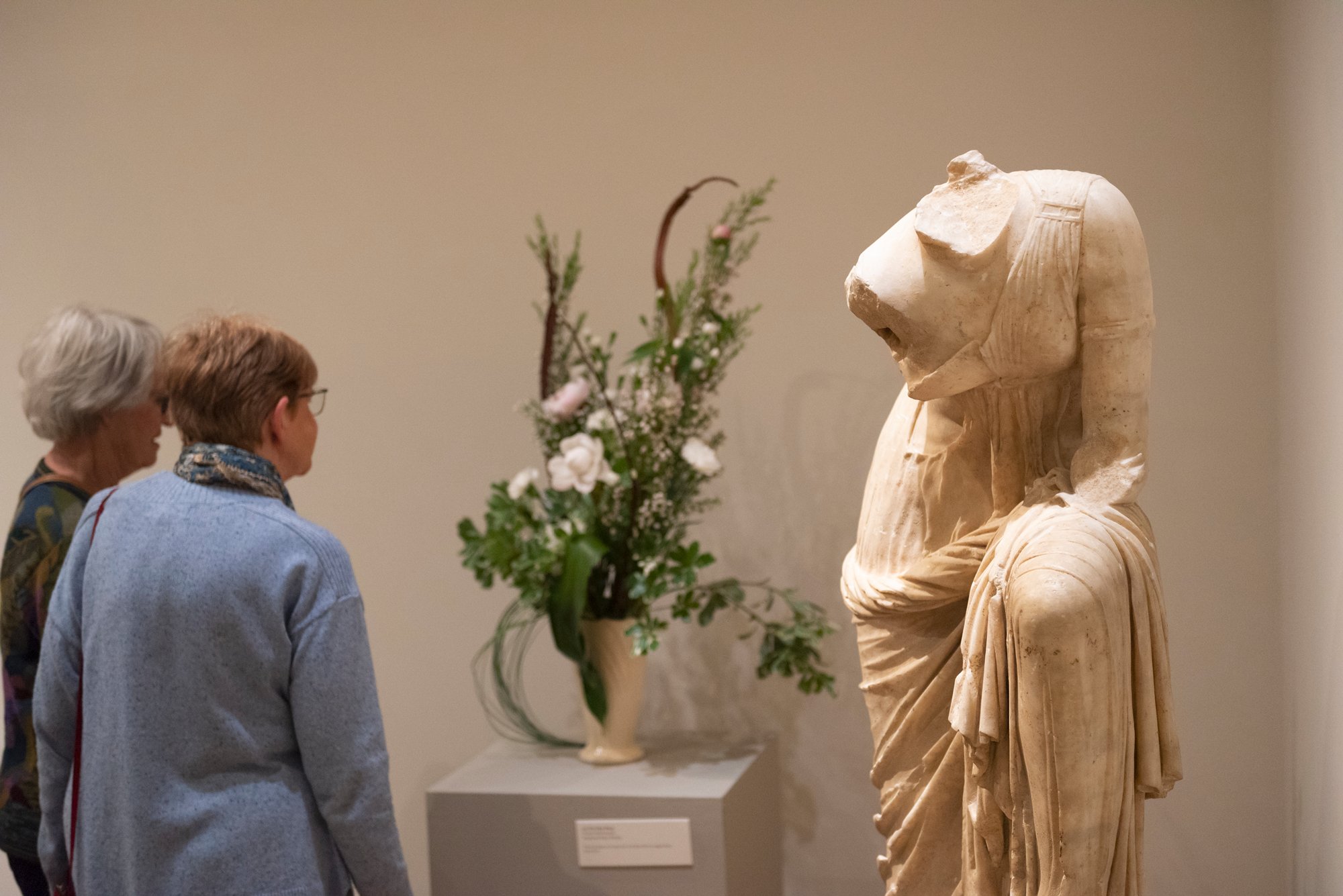 Two people viewing a floral interpretation of an artwork.