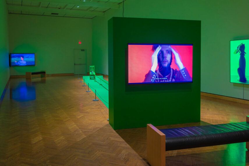 large room with hard wood floors and lit television screens covered in a deep green light