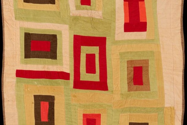 image of a quilt with red, brown, light yellow, and light green rectangles against a cream background