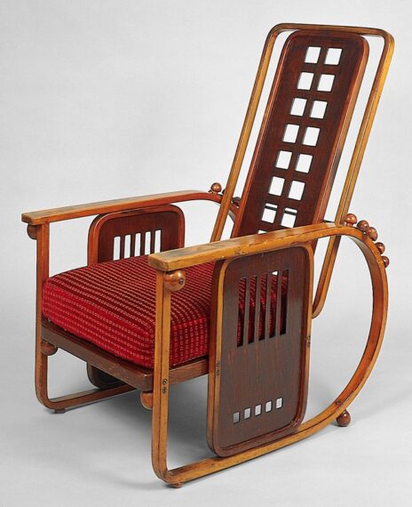 Reclining armchair from the early 1900s with light-colored wood and a red cushion
