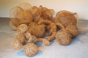 Photo of a mound of woven bamboo orbs and tubes amassed together