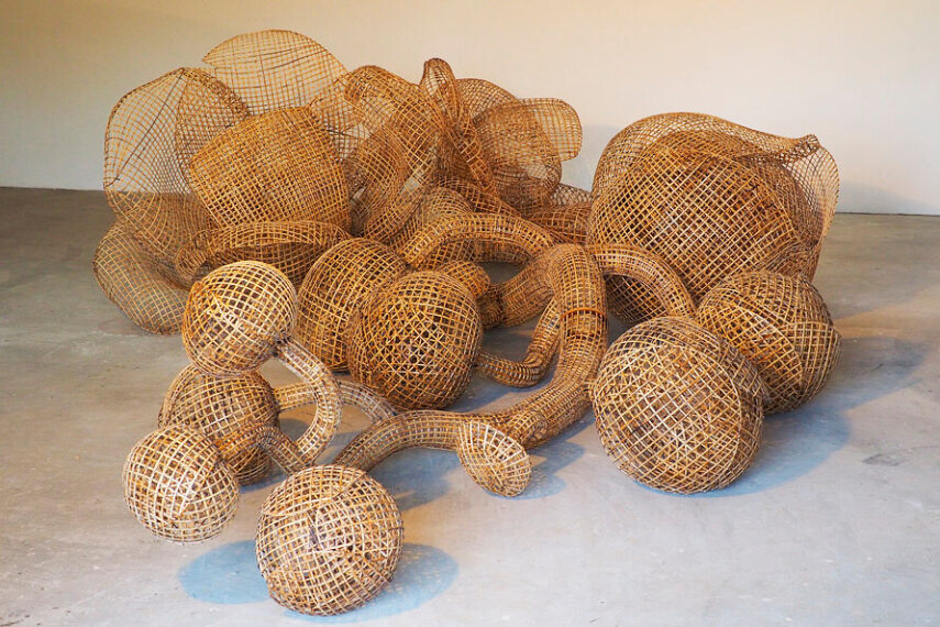 Photo of a mound of woven bamboo orbs and tubes amassed together