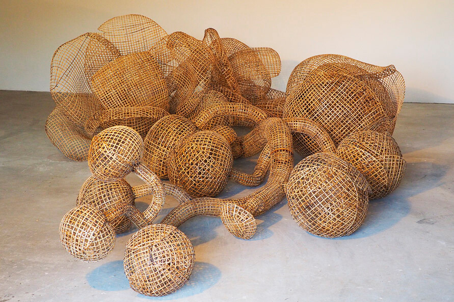 Photo of a mound of woven bamboo orbs and tubes amassed together