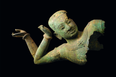 bronze sculpture of a reclining Vishnu showing his face with two arms bent at the elbow