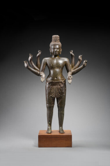 Bronze statue of a god with eight arms standing upright