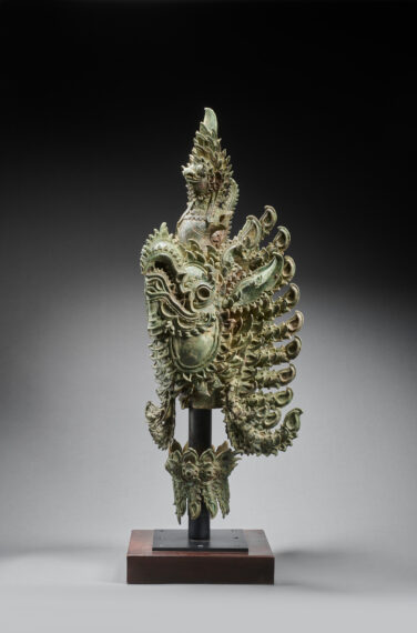 bronze dragon-like statue with a light green hue