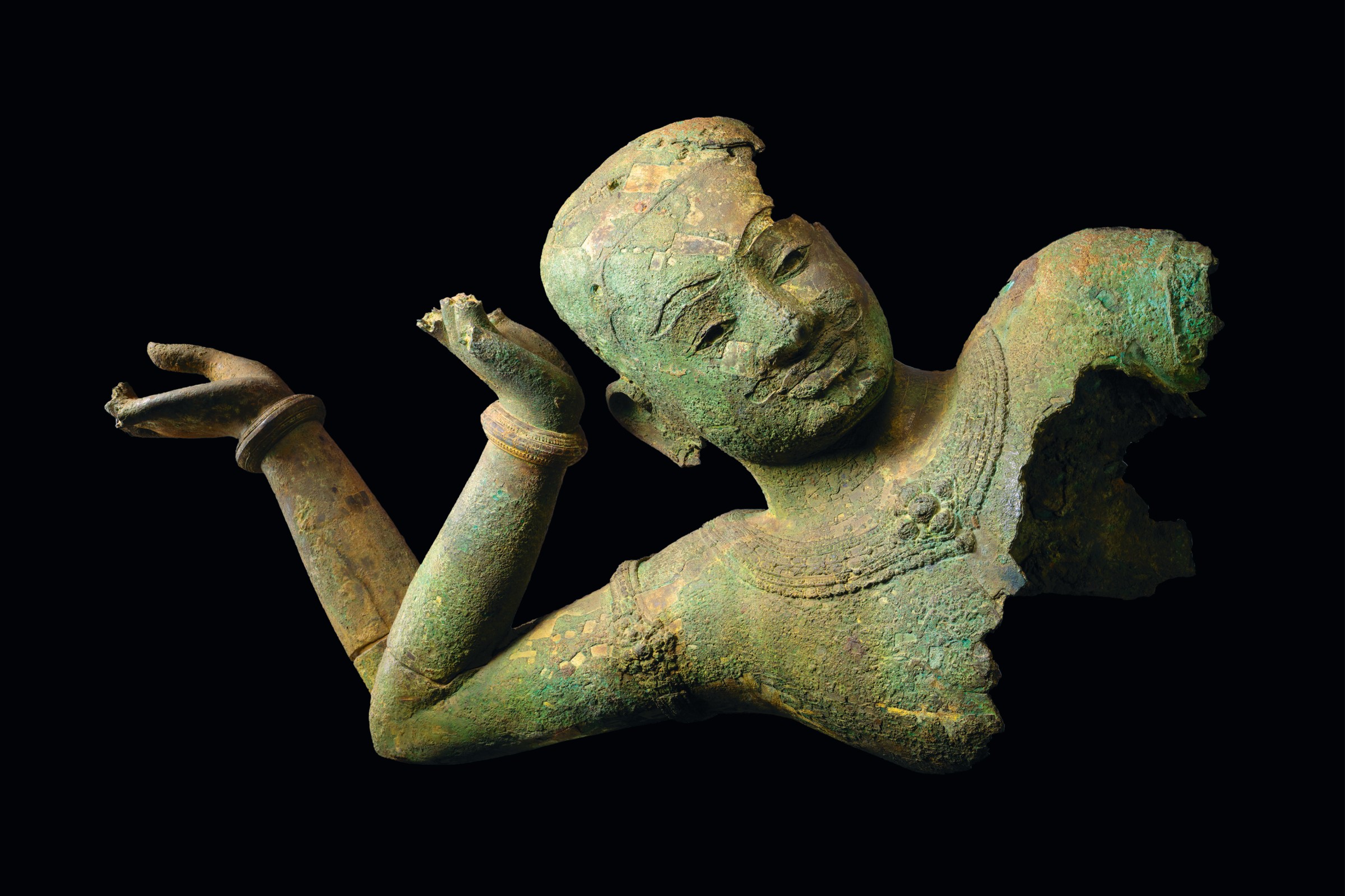bronze sculpture of a reclining Vishnu showing his face with two arms bent at the elbow