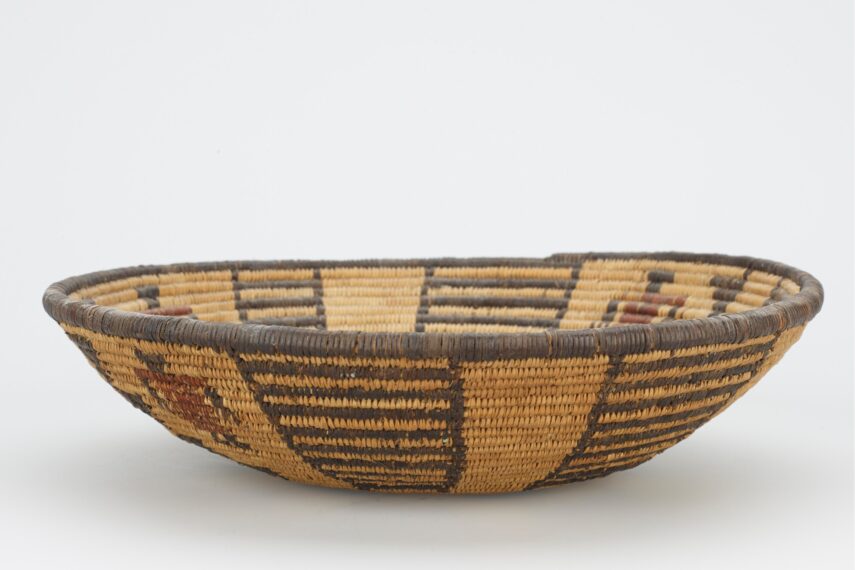 black and tan woven bowl with black flower in center; four ladder designs and 3 figures with red tunics