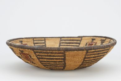 black and tan woven bowl with black flower in center; four ladder designs and 3 figures with red tunics