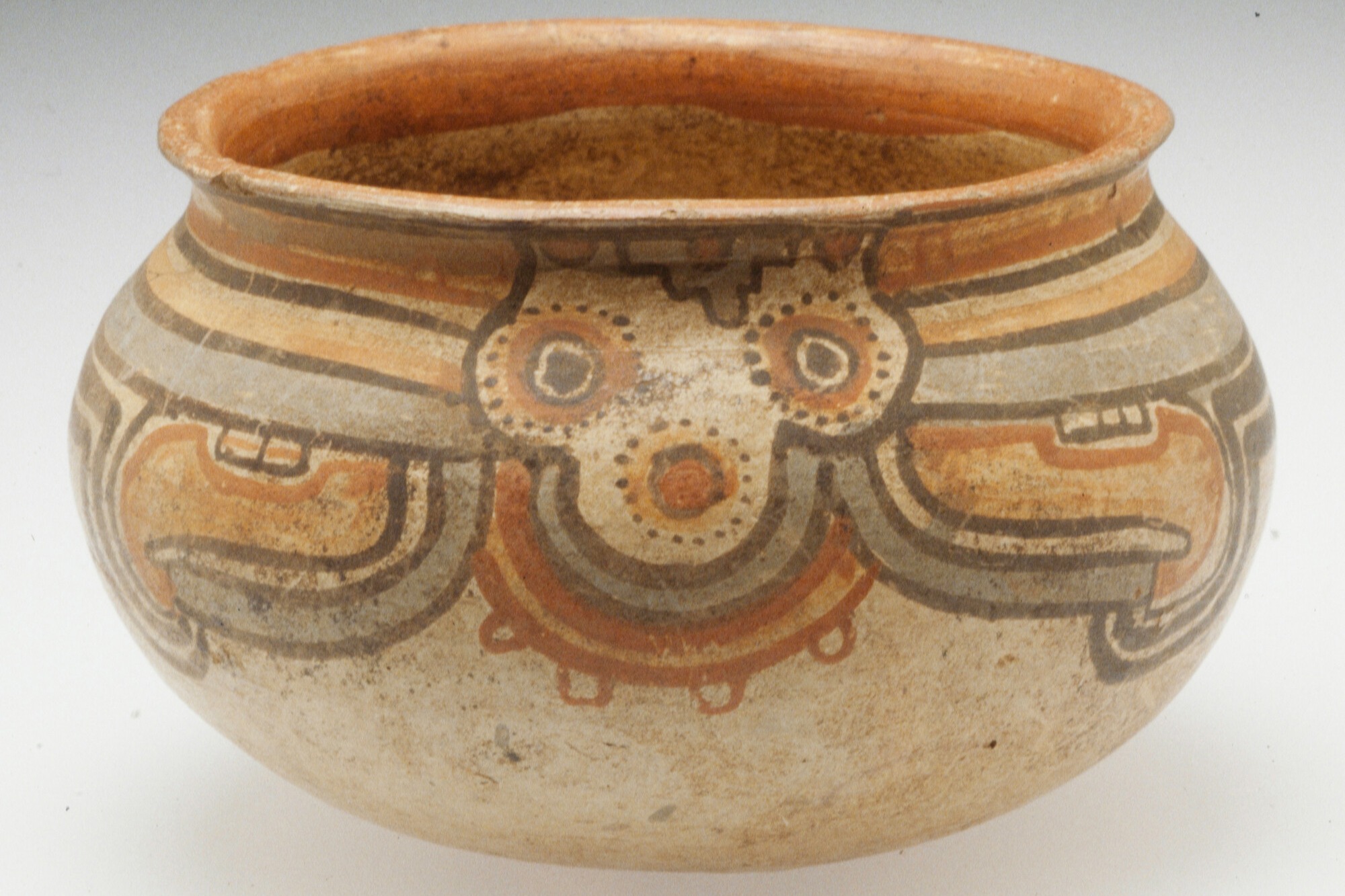Photo of a earthenware pot, decorated in lines and circles in beige, earthy colors