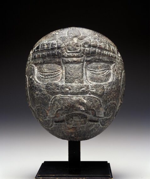 Gray stone mask mounted on a pedestal