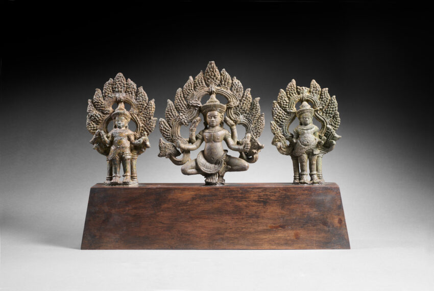 Three statues of the Hindu god Vishnu a top a wooden block