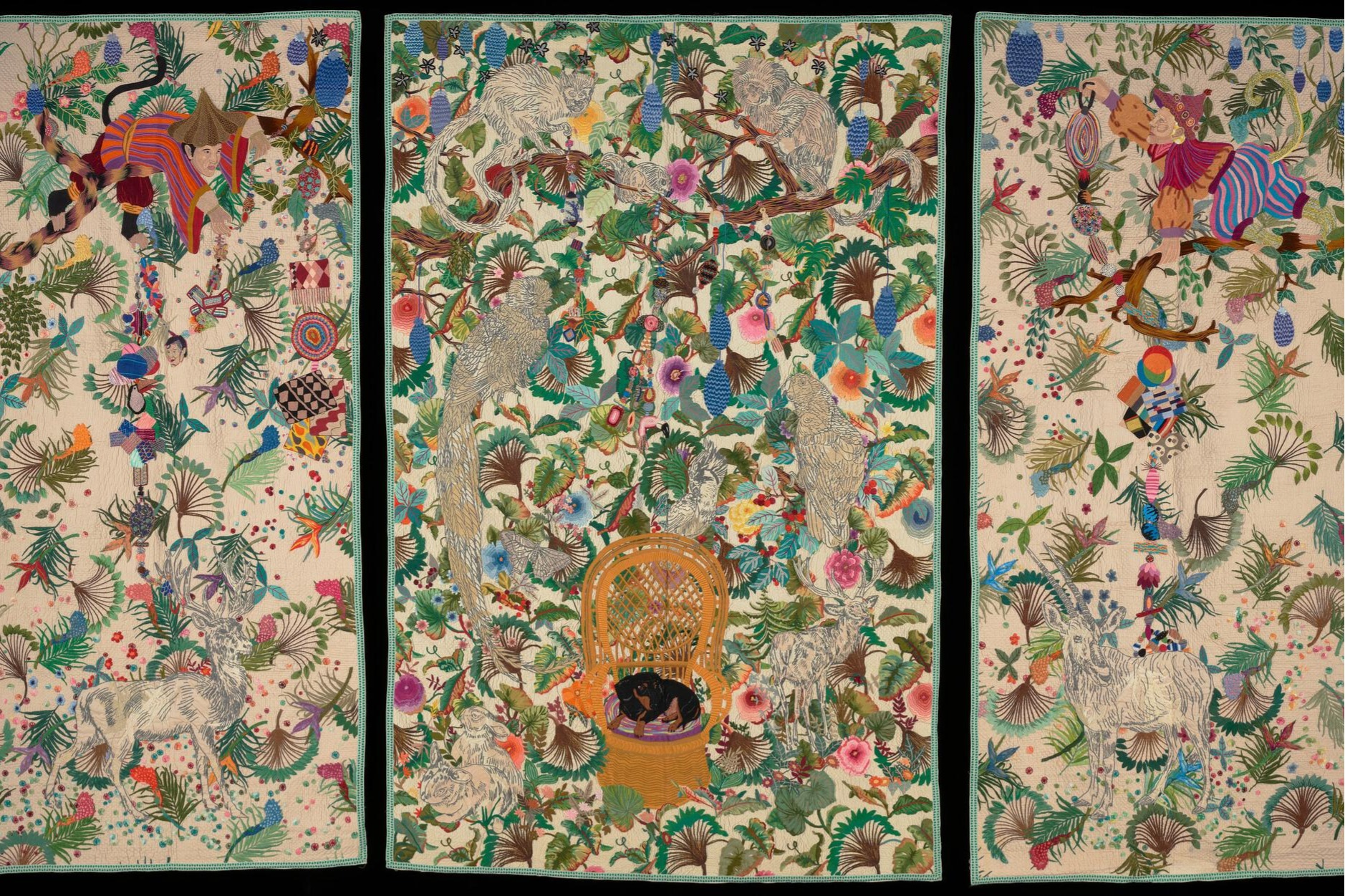 large three-panel colorful embroidered textile depicting plants and animals of the rainforest against an off-white ground
