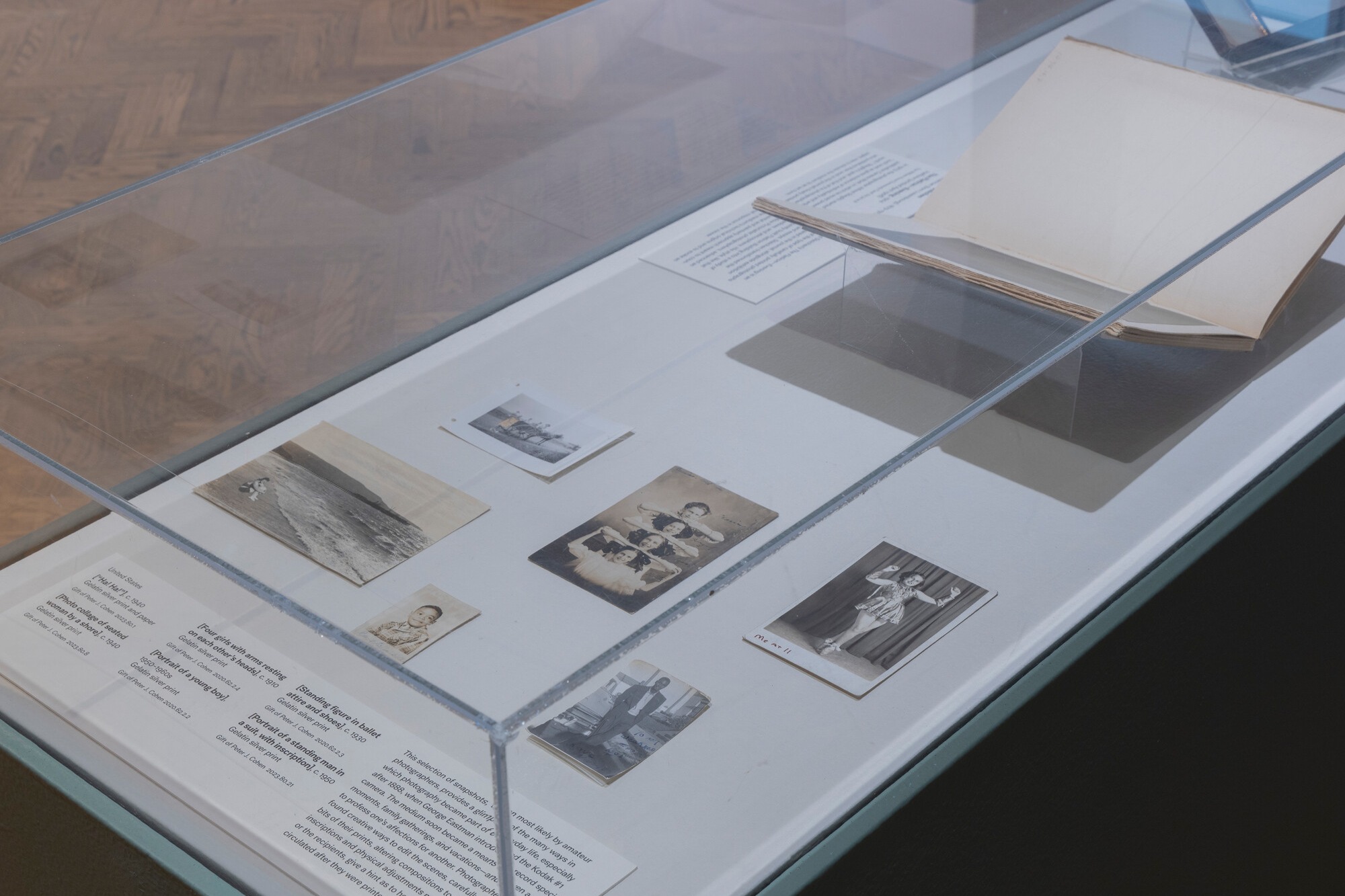 Photograph of black-and-white and sepia-toned photos in a glass case