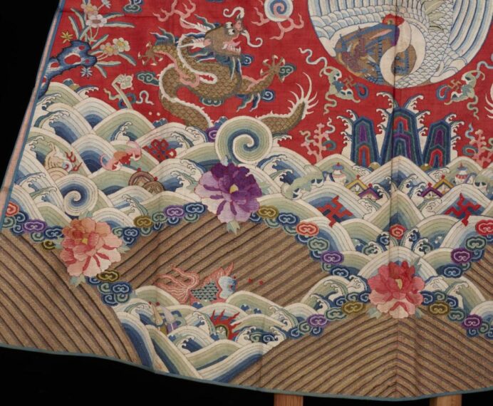 Intricate embroidery with dragon, phoenix, waves, and flowers.