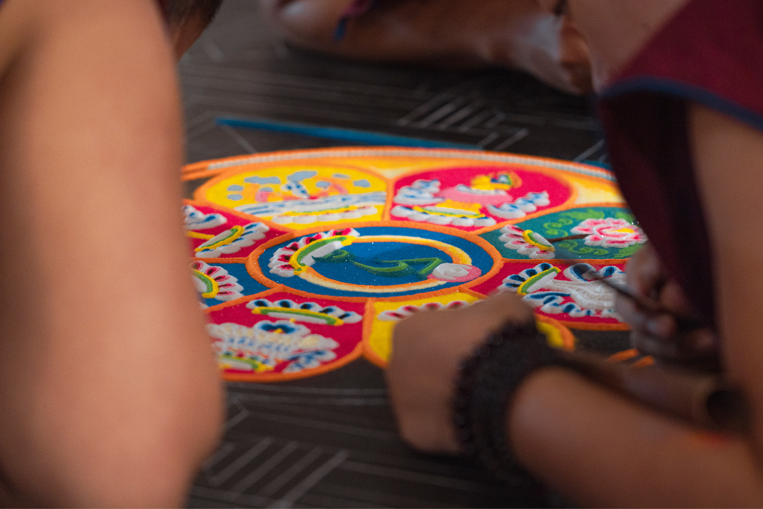 Close-up of a colorful sand mandala being created.