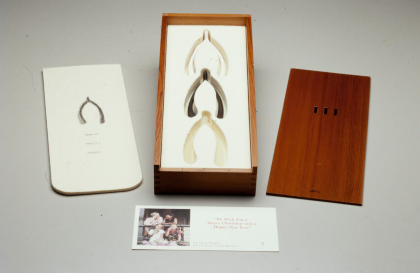 Wooden box with wishbones and cards on display.