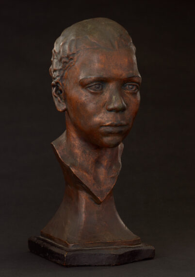 Bronze bust of a young person with short hair on a dark background