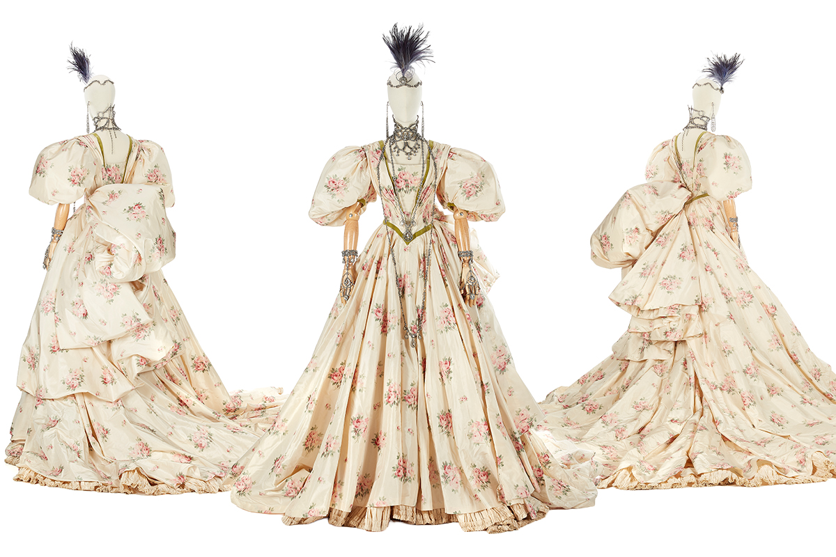 Vintage floral gown with puffed sleeves on a mannequin.