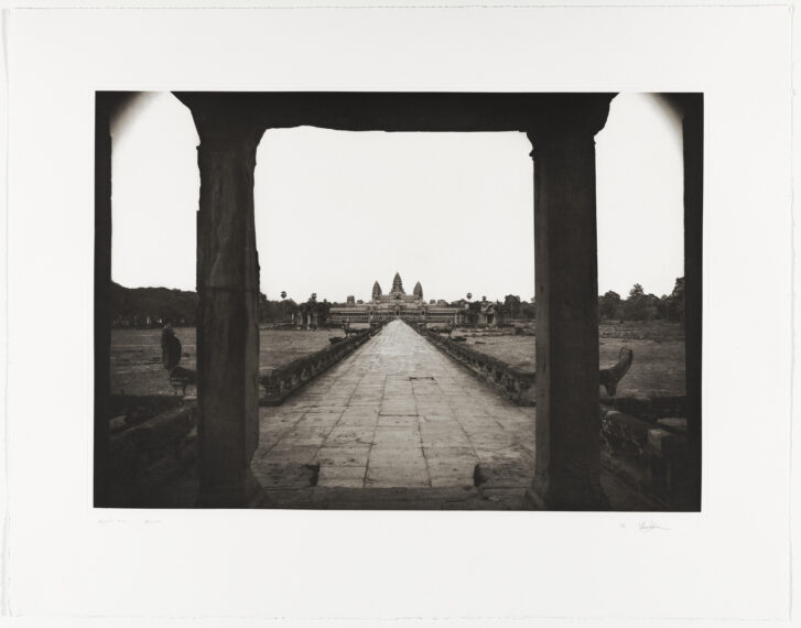 View through a stone archway to a distant temple.