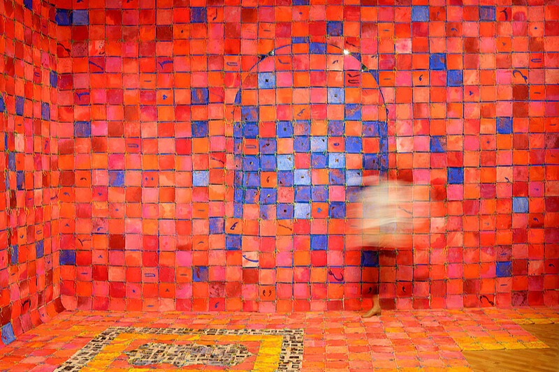 Photo of a wall made up of small squares in bright red, orange, pink, and blue