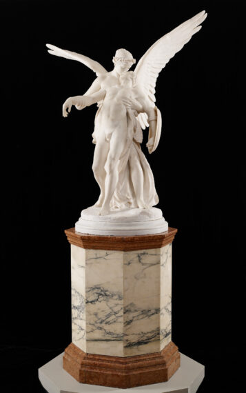 Marble statue of two intertwined figures with wings on a pedestal.