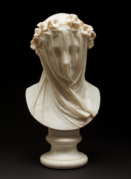 Marble bust of a woman with a delicate veil draped over her face, obscuring her features. The sculpture is crafted with intricate detail, capturing the soft folds of the veil, which cling closely to the contours of her face.