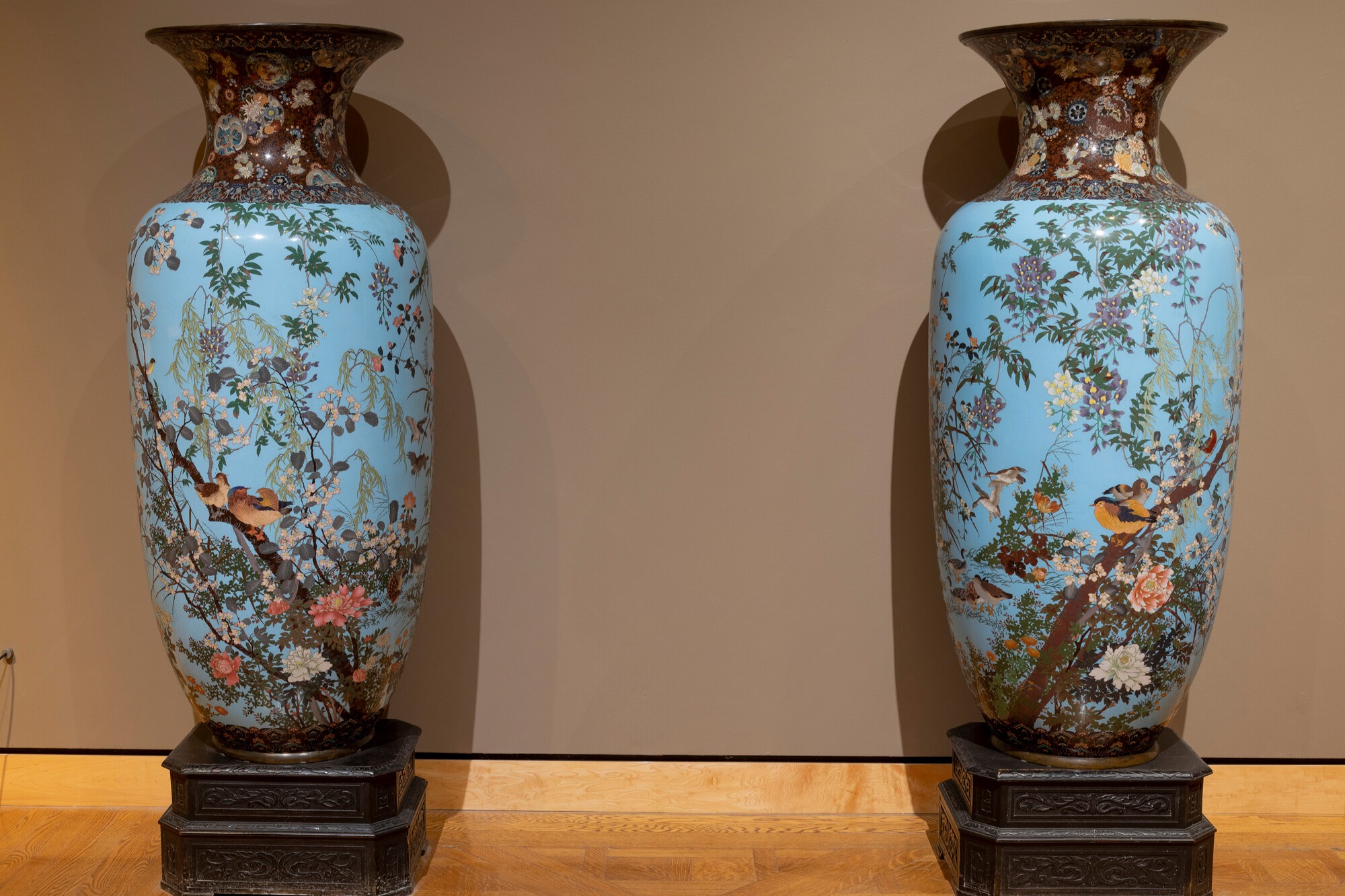 Two ornate vases with floral and bird designs on a light blue background.
