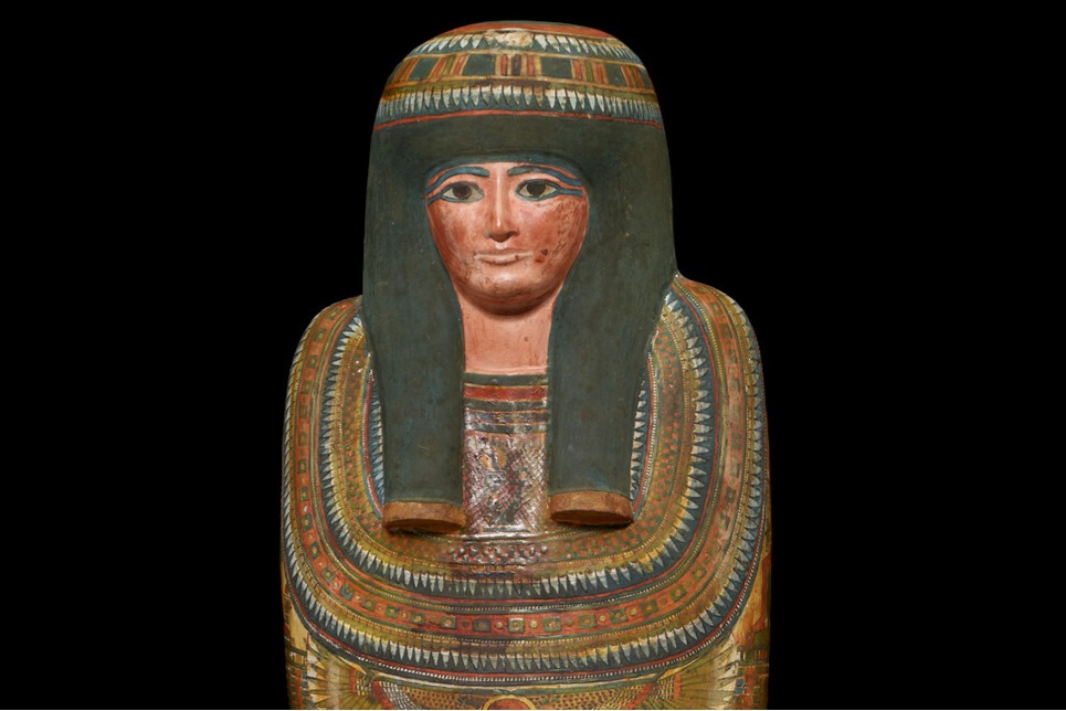 Decorated ancient Egyptian sarcophagus on a black background.