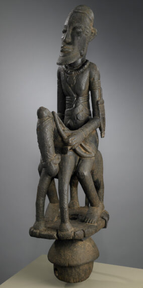 Sculpture of a seated figure on an animal.