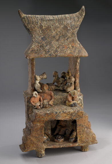 Ceramic structure with human figures and decorative patterns.