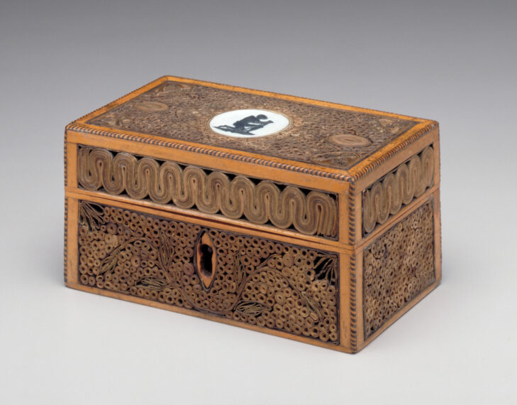 Intricately carved wooden box with relief patterns.