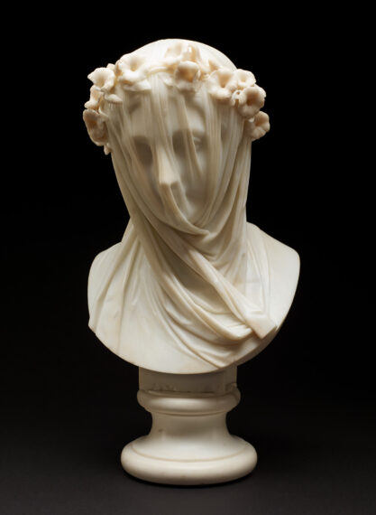 Marble bust of a woman with a delicate veil draped over her face, obscuring her features. The sculpture is crafted with intricate detail, capturing the soft folds of the veil, which cling closely to the contours of her face.