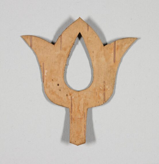 Wooden cutout in the shape of a stylized tulip on a light background