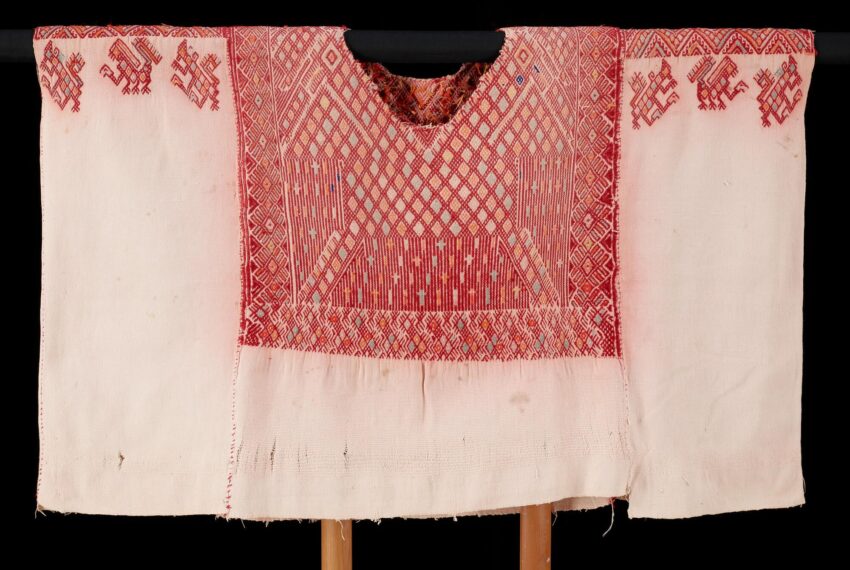 White garment with red geometric embroidery.