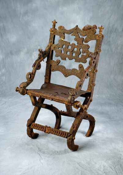 Ornate wooden chair with carved patterns and decorative elements.