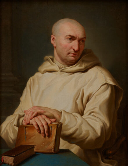 The image depicts a bald person wearing a light-colored robe. They are sitting and have their hands resting on the top of a closed leather book on a table.