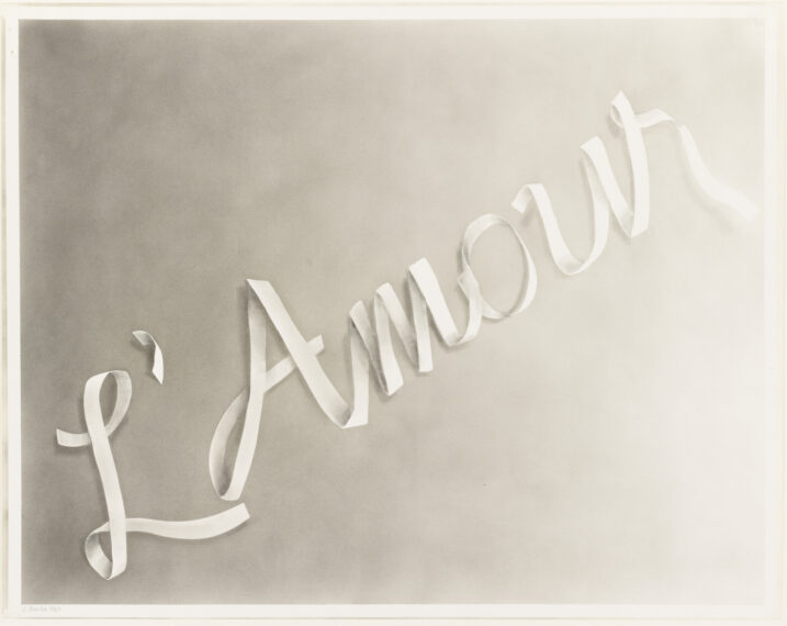 Ribbon-like letters spelling 'L'Amour' on a gray background