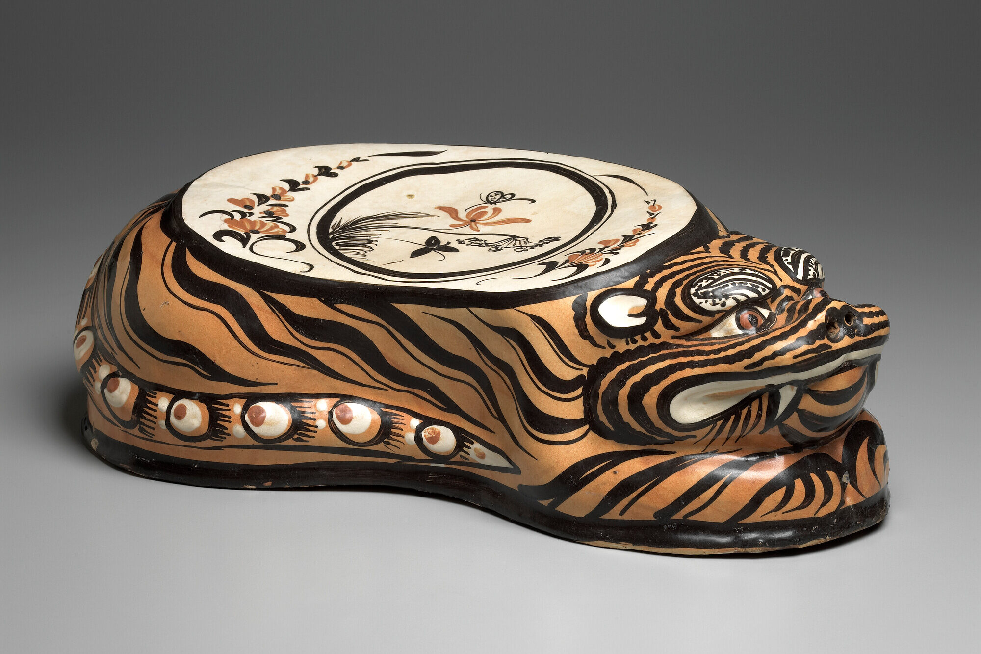 The image shows a decorative ceramic object with a tiger stripe pattern in orange and black.