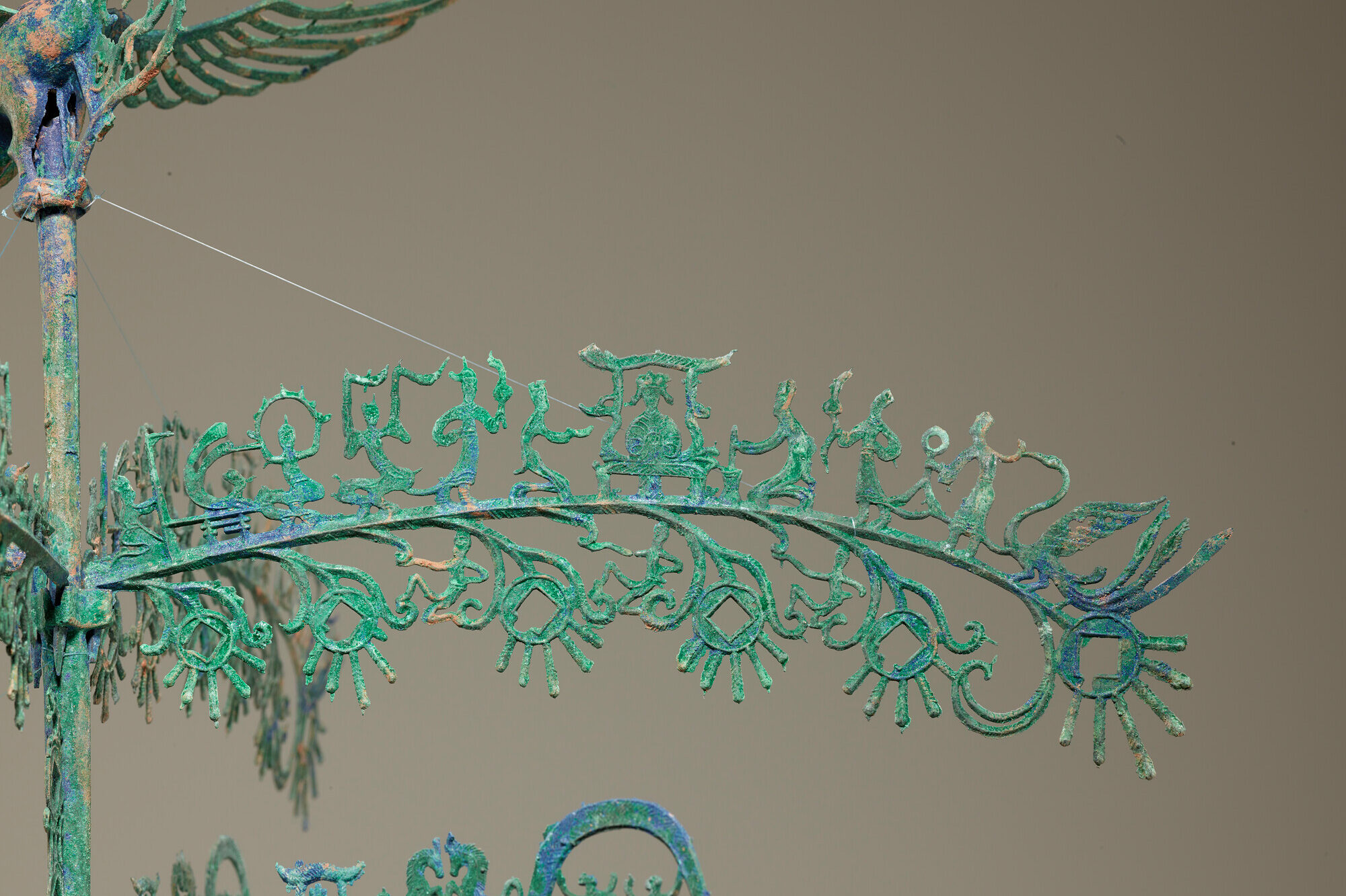 Intricate green metallic sculpture with detailed patterns.
