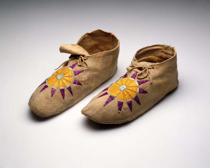 Pair of beige moccasins with colorful star patterns on top