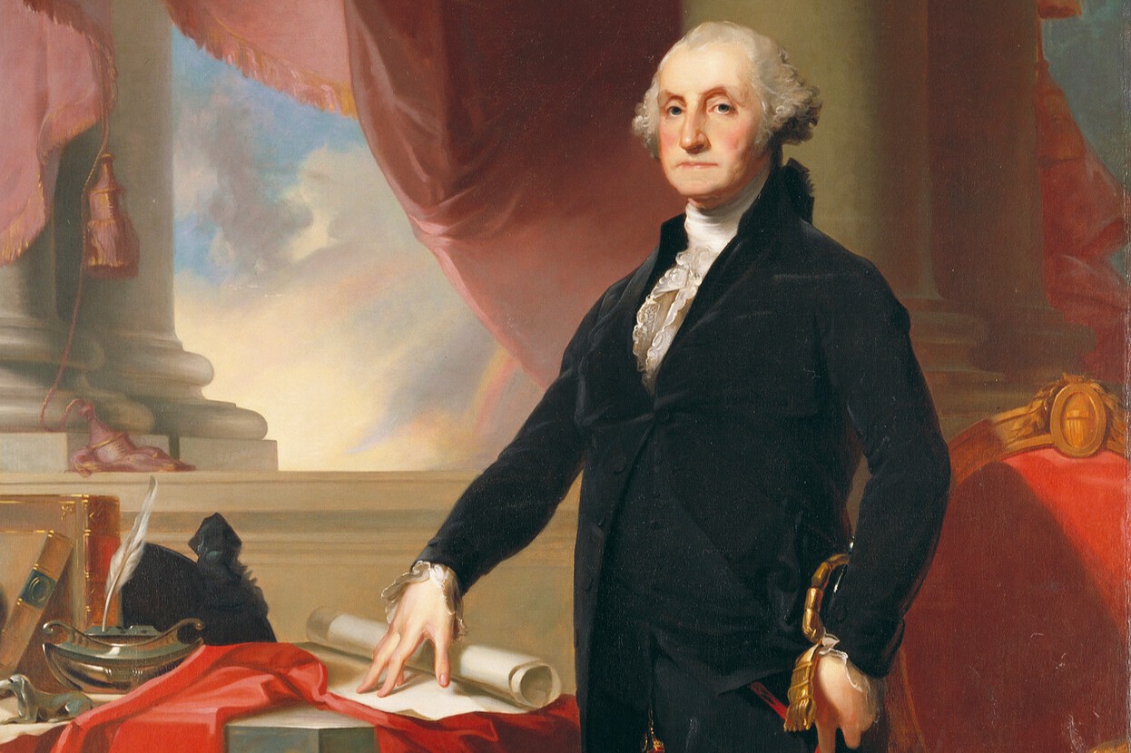 The image shows a man dressed in a black coat, white shirt, and black breeches standing to the right of a table. The table is covered with a rich red curtain-like cloth and several objects, including books, papers, and a quill pen.