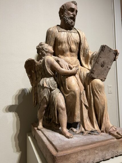 Statue of a seated bearded man with a tablet and a standing angel.