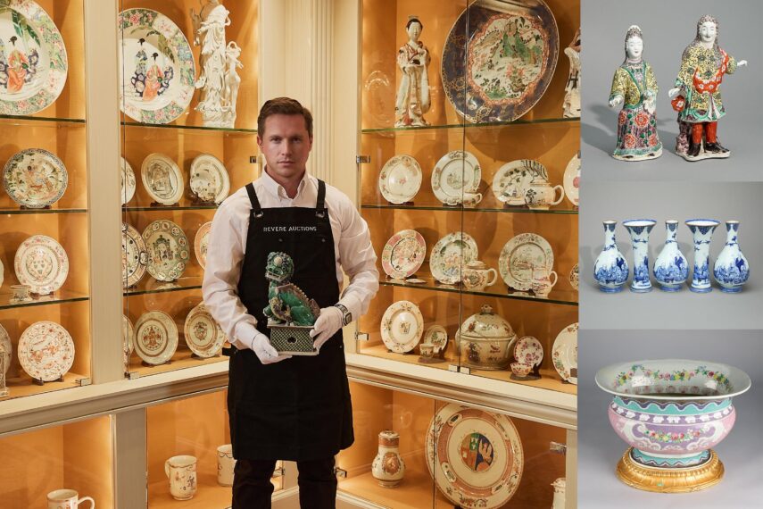 The image shows a person standing in front of glass shelves containing an array of ceramic items, including plates, cups, and figurines. The person is wearing a dark apron with the words 'Revere Auctions' embroidered on it and is holding a green ceramic statue on a small platform.