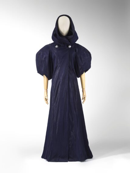 Mannequin wearing a dark blue hooded dress with puffed short sleeves.