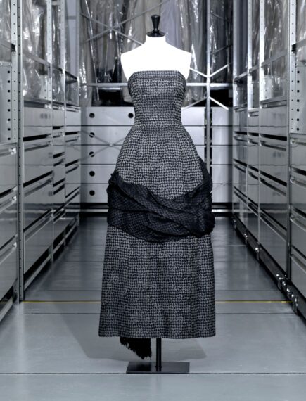 The image shows a mannequin dressed in a strapless, high-waisted houndstooth-pattern dress.